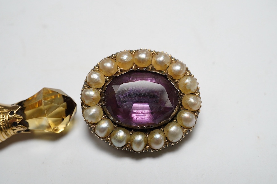 An early 20th century yellow metal, gem and Scottish hardstone set dirk brooch, 55mm, together with a George IV yellow metal, amethyst and split pearl set oval mourning brooch. Condition - poor to fair